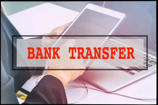 Hand and text BANK TRANSFER with vintage background. Technology concept.