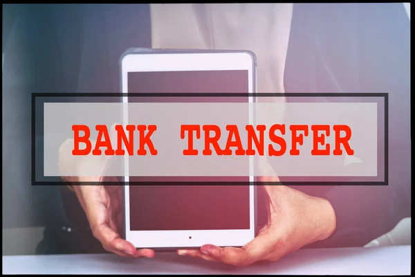 Hand and text BANK TRANSFER with vintage background. Technology concept.