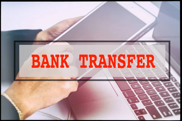 Hand and text BANK TRANSFER with vintage background. Technology concept.