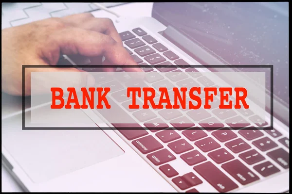 Hand and text BANK TRANSFER with vintage background. Technology concept.