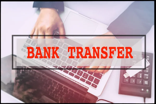 Hand and text BANK TRANSFER with vintage background. Technology concept.