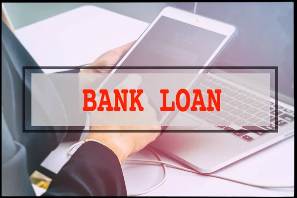 Hand and text BANK LOAN with vintage background. Technology concept.