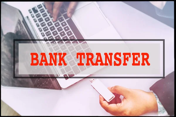 Hand and text BANK TRANSFER with vintage background. Technology concept.