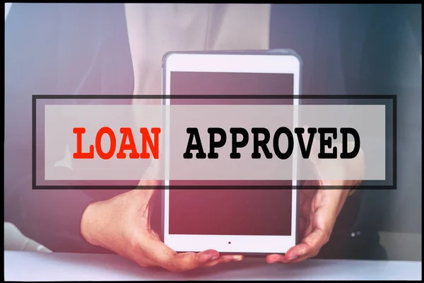 Hand and text LOAN APPROVED with vintage background. Technology concept.