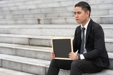 İşadamı ofis merdivenlerinde oturuyor..