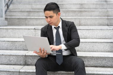 İşadamı ofis merdivenlerinde oturuyor..