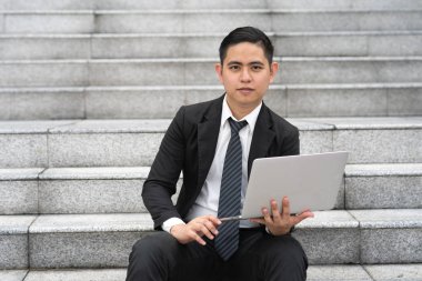 İşadamı ofis merdivenlerinde oturuyor..