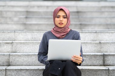 İş kadını ofis merdivenlerinde oturuyor..