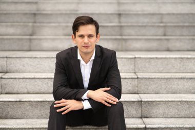 İşadamı ofis merdivenlerinde oturuyor..