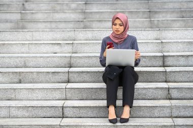 İş kadını ofis merdivenlerinde oturuyor..