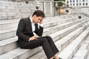 İşadamı ofis merdivenlerinde oturuyor..