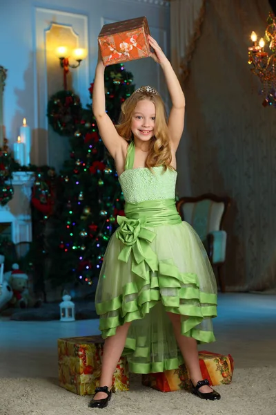 新年のツリーの背景のギフト ボックスでお祝い緑のドレスで美しいブロンドの子女の子を魅力的な美しい — ストック写真