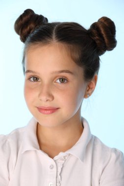 Yakın çekim bir büyüleyici oldukça stil sahibi genç genç kız öğrenci portresi. Güzel esmer çocuk bakıyor ve gülümsüyor. Küçük kız 12 yaşındaki eski saç modeli ile beyaz bir bluz.