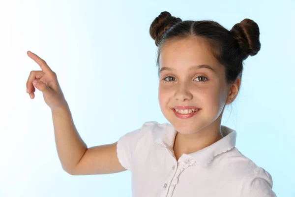 特写肖像的一个漂亮的年轻少女女孩 美丽的黑发孩子微笑着 用手指指着点 快乐的小女孩12岁在白色上衣与发型 — 图库照片