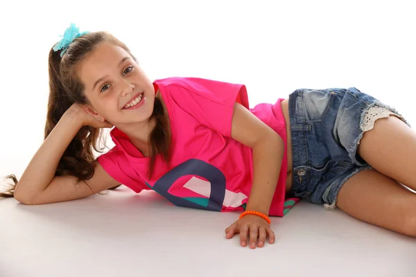 Bir yalancı çekici genç esmer kız öğrenci kot şort ve parlak bir üst portresi. Güzel spor çocuk uzun siyah saçlı ve ince bir vücut. Çıplak ayaklı gülümseyen mutlu kız.