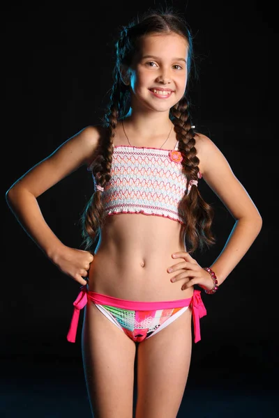 İnce gövdeli ayakta büyüleyici bir çocuk portresi. Genç ve güzel güzel kız çıplak oryantal parlak bikinili poz ile. Çekici genç genç gülümseyen ve mutlu.