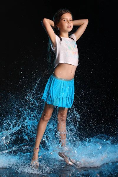 Çekici ince çocuk sessizce üzerinde tam vücut ayakta. Genç ve güzel güzel kız ıslak elbise ve etek çıplak ayaklı. Su sıçramalarına çekici yound genç.