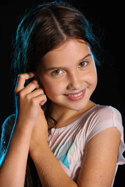 Yakın çekim ıslak ince vücut ile büyüleyici bir çocuk portresi. Islak elbiseleri genç ve güzel güzel esmer kız. Çekici oynak genç gülümseyen ve mutlu.