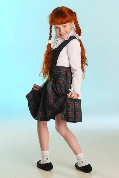美丽快乐的小红头发女孩显示她的校服在全长 优雅迷人的孩子与苗条的身体和苗条的裸腿 这个年轻的女学生8岁了 — 图库照片