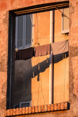 Sokak lambaları ve kıyafetleri kuruması için asılmış Roma cephesi
