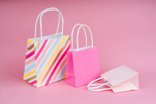 Бумажные покупки или подарочные пакеты на розовом фоне с копией спа в том числе . — стоковое фото