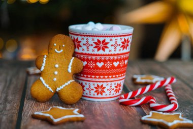 Noel kartpostalında zencefilli kurabiye, kırmızı bardak ve noel kartı.