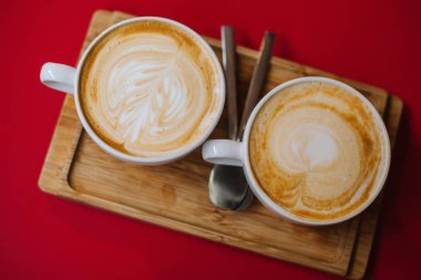 Kafedeki sütlü kahveyle birlikte sıcak kapuçino bardağı.