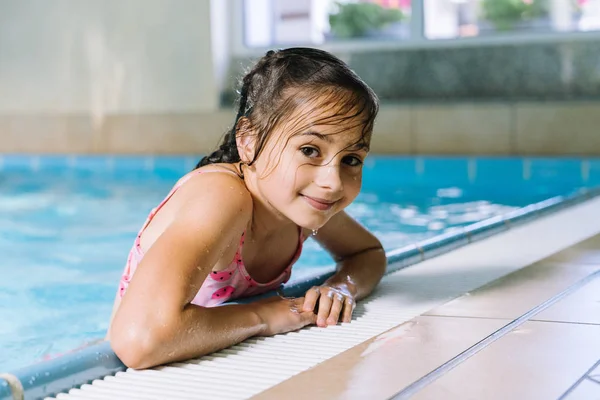 Ritratto bambina che si diverte nella piscina coperta. Il gir — Foto Stock