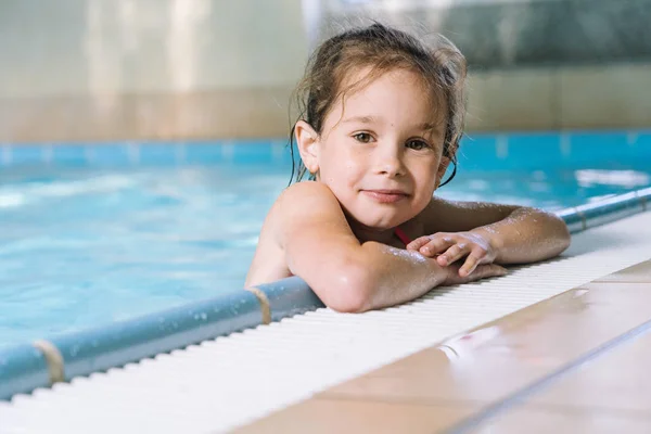 Ritratto bambina che si diverte nella piscina coperta. Il gir — Foto Stock
