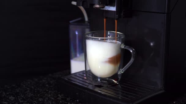 Nalévací kávový proud z automatického kávovaru v šálku. 