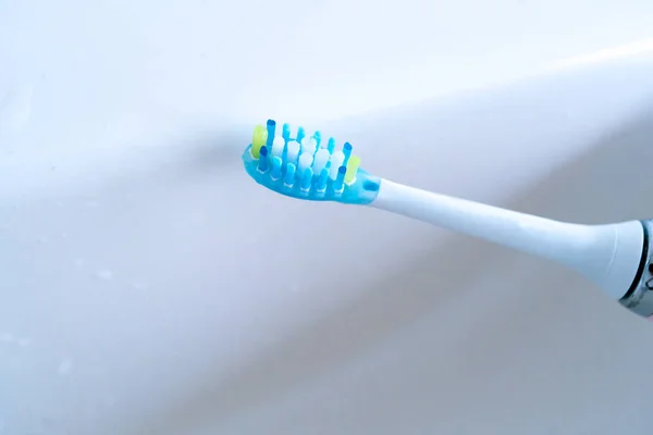 Pink electric toothbrushes and glass in the bathroom at home. — Stock Photo, Image