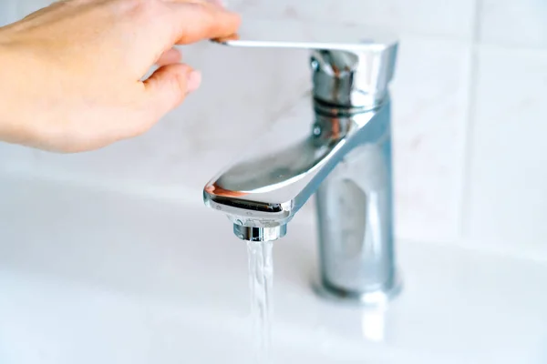 Washing hands person for coronavirus prevention, hygiene to stop spreading covid-19 in bathroom. Washing hands under under running water tap or faucet without soap. Hygiene and protection concept — Stock Photo, Image