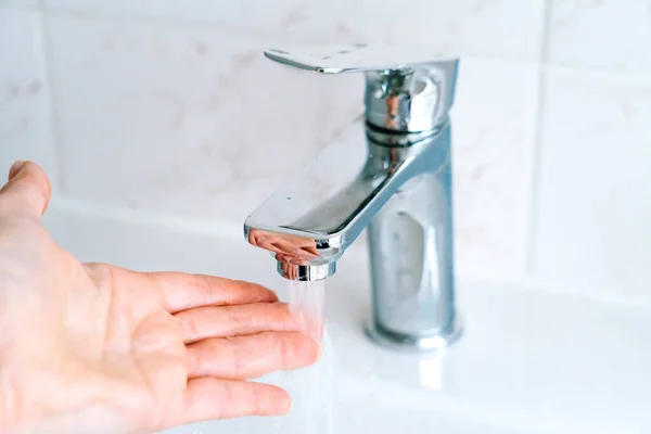 Washing hands person for coronavirus prevention, hygiene to stop spreading covid-19 in bathroom. Washing hands under under running water tap or faucet without soap. Hygiene and protection concept — Stock Photo, Image