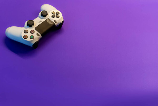 white controller on purple background top view