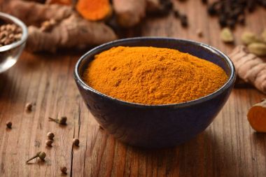 Tumeric ahşap arka plan üzerinde bir kasede.
