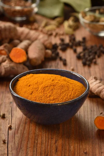 Tumeric ahşap arka plan üzerinde bir kasede. — Stok fotoğraf