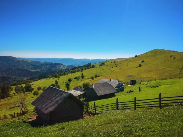 Une cabane en bois sur les montagnes avec prairie verte — Photo