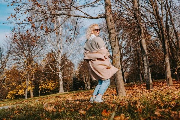 Krásná žena v podzimním parku skákání a usmívání — Stock fotografie