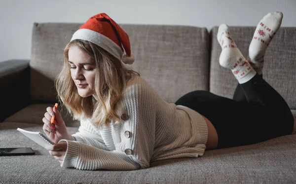 El retrato de la muchacha bonita en Navidad escribe los planes para un nuevo año —  Fotos de Stock