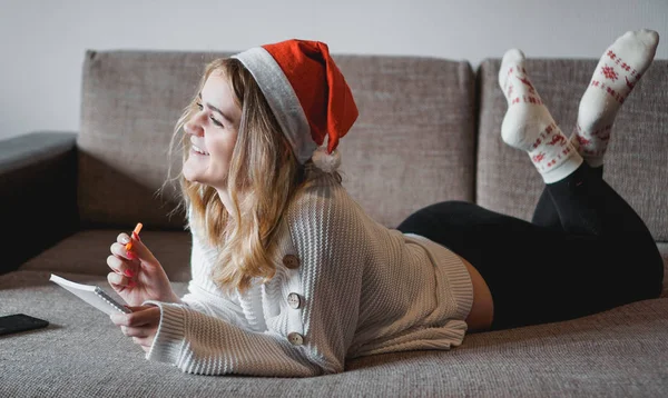 El retrato de la muchacha bonita en Navidad escribe los planes para un nuevo año —  Fotos de Stock