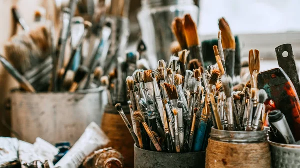 Mesa con cepillos y herramientas en taller de arte. Contexto . —  Fotos de Stock
