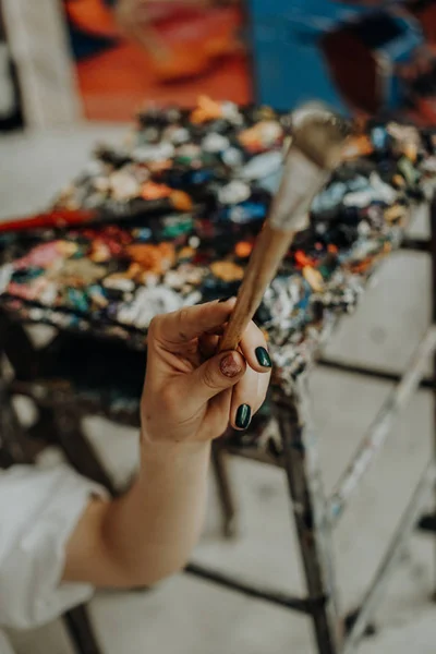 Primo piano di mano artista femminile che tiene pennello — Foto Stock