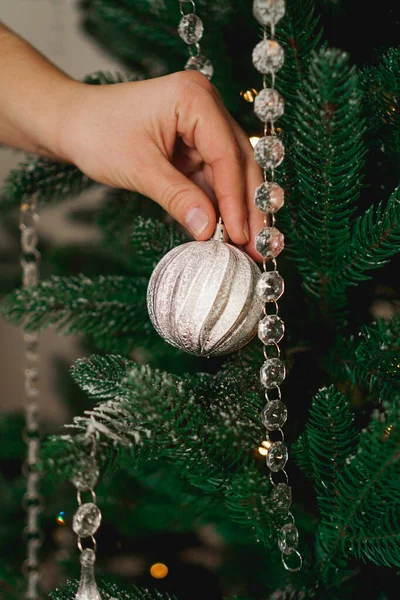 Mão feminina decorando árvore de Natal com bolas de prata . — Fotografia de Stock