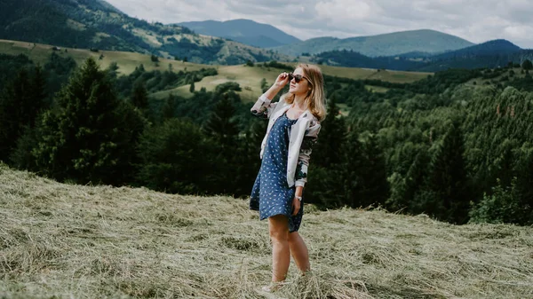 Frau steht auf dem Berggipfel und blickt auf das Bergpanorama — Stockfoto