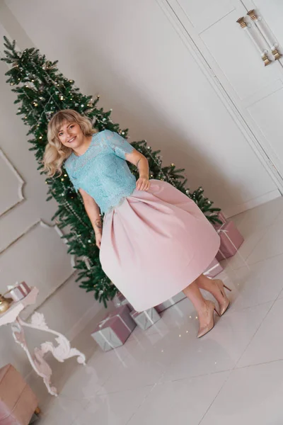 Hermosa mujer cerca del árbol de Navidad sonriendo bailando en hermoso vestido, año nuevo — Foto de Stock