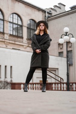 Şapka takan genç bir kadın, şehre bakıyor ve poz veriyor, Avrupa 'da.