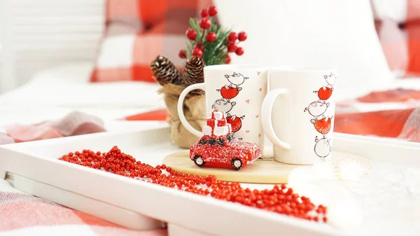 Taza roja de Año Nuevo o Navidad en bandeja blanca en la cama con luces — Foto de Stock