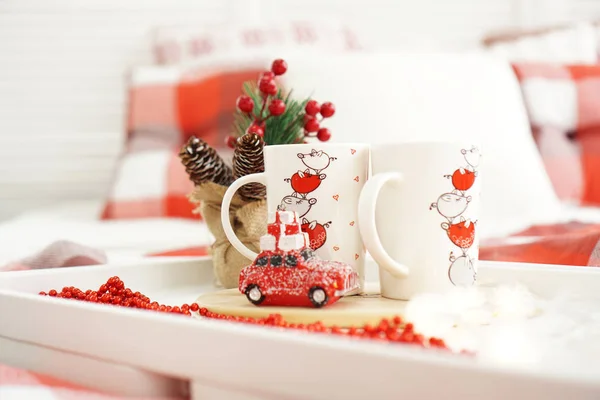 Taza roja de Año Nuevo o Navidad en bandeja blanca en la cama con luces — Foto de Stock