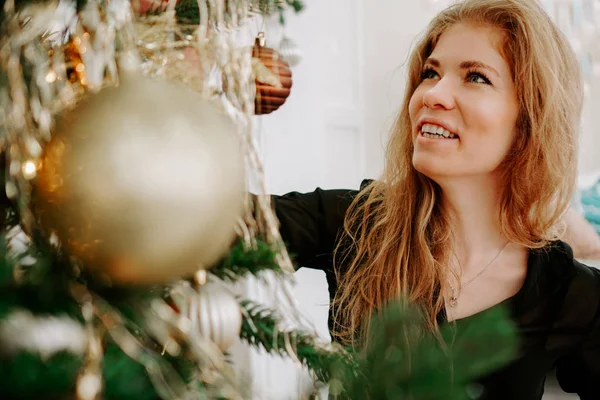 Hermosa joven mujer decorando un árbol de Navidad —  Fotos de Stock