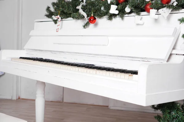 Ключи на белом фортепиано с рождественским декором — стоковое фото